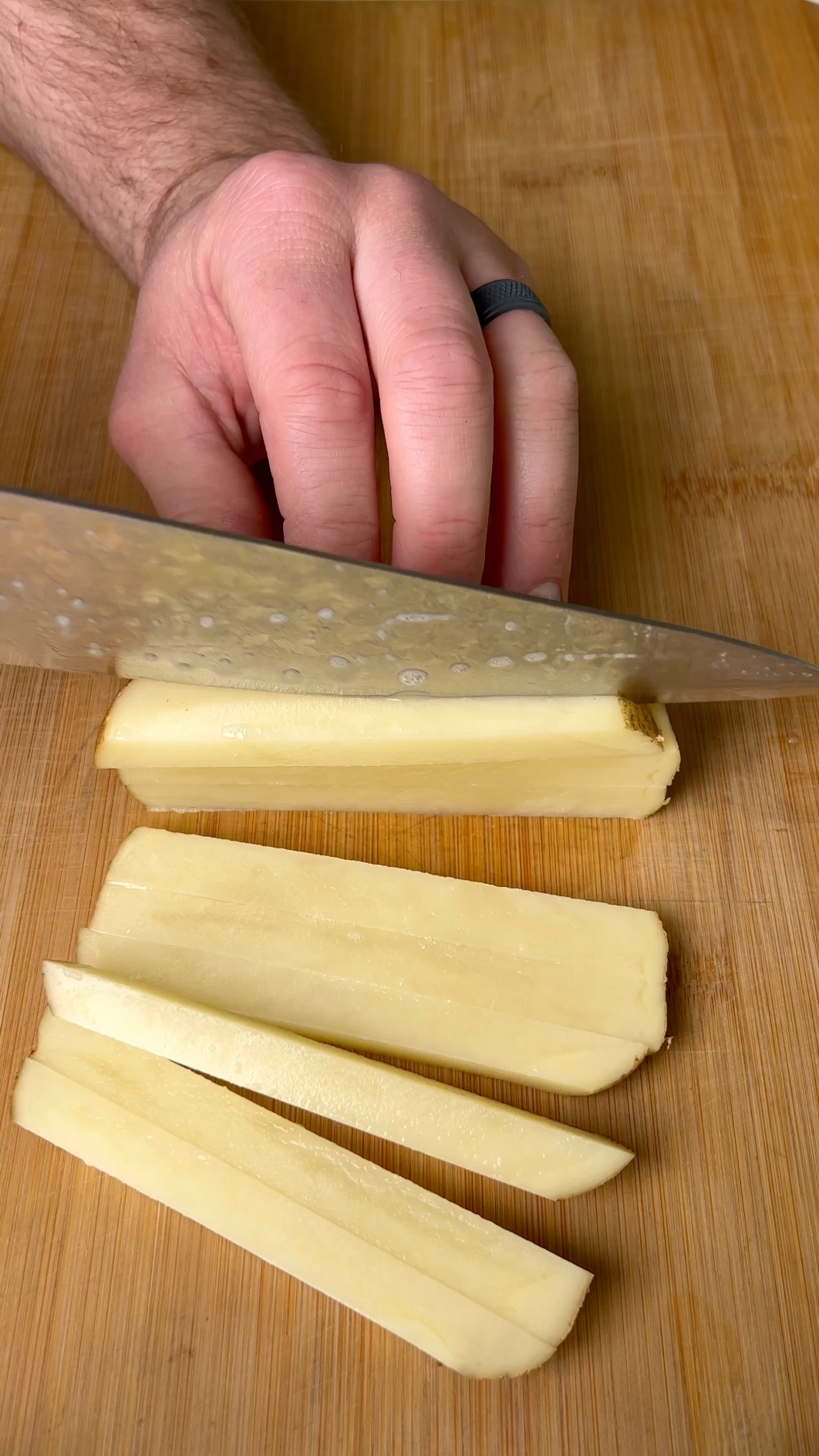 Making homemade french fries from a sliced russet potato for steak frites 