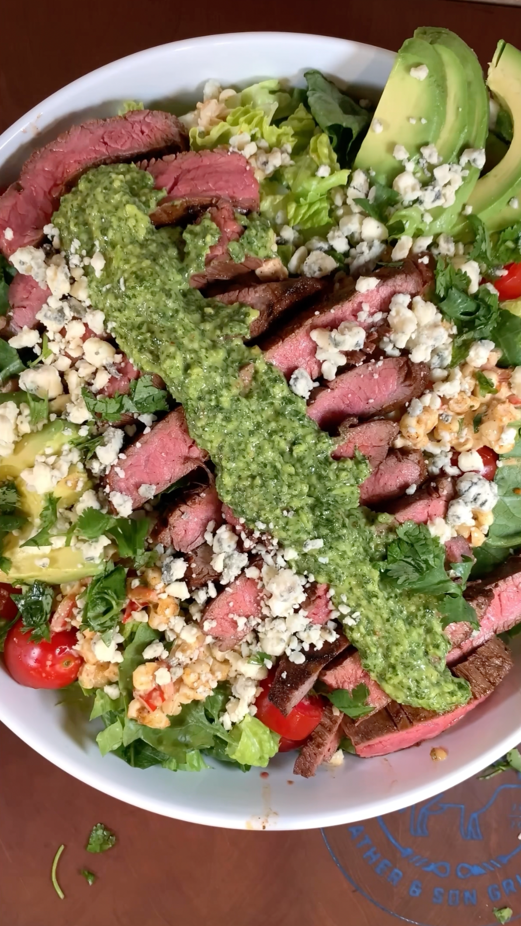 Grilled flank steak salad with betterfed beef certified onya beef, avocado, tomato, lettuce, lime, chimichurri dressing, and corn salas