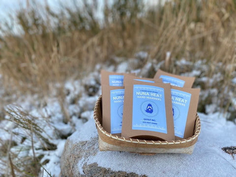 Nuna Heat hand warmers sit outside in a birchbark basket