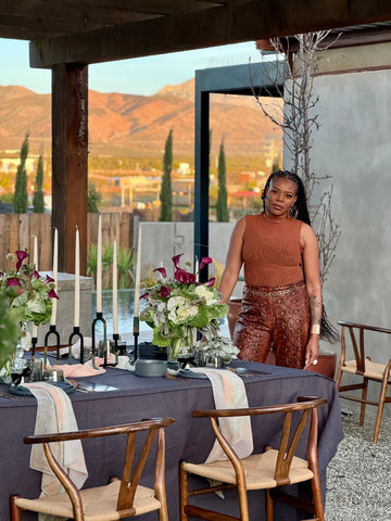 Photo of Erin standing by a decorated table with mountains in the background.