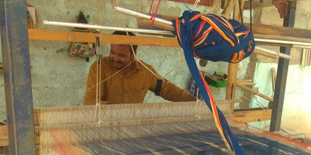 a weaver weaving Bhujodi saree on handloom