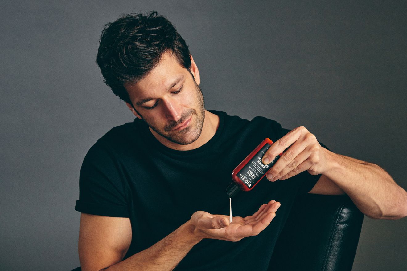 Man squeezing hand cream into hands