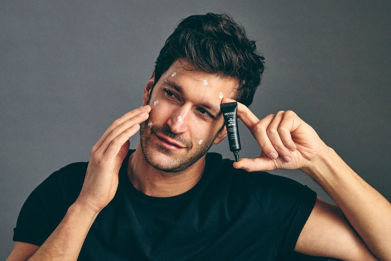 Man applying acne spot stick to face