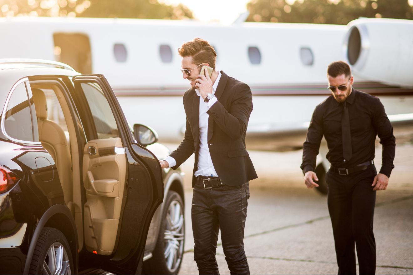 Men getting into luxury car