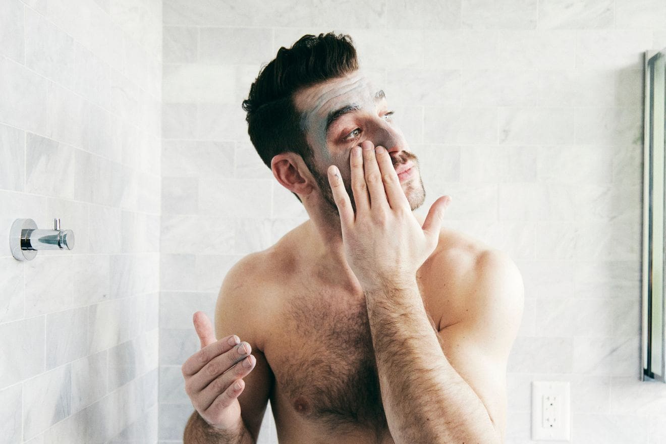 Man applying skincare face mask