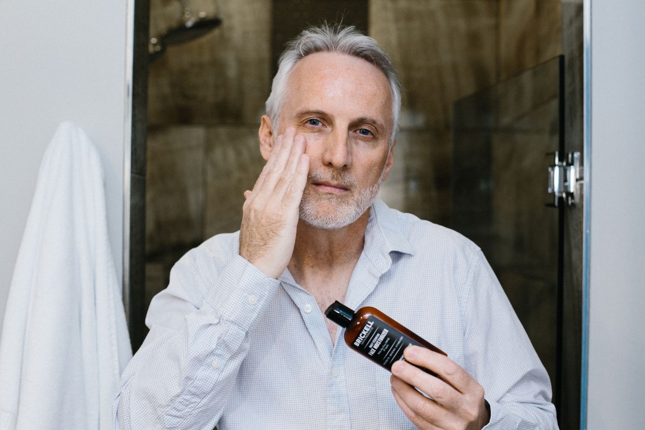 Man applying face moisturizer