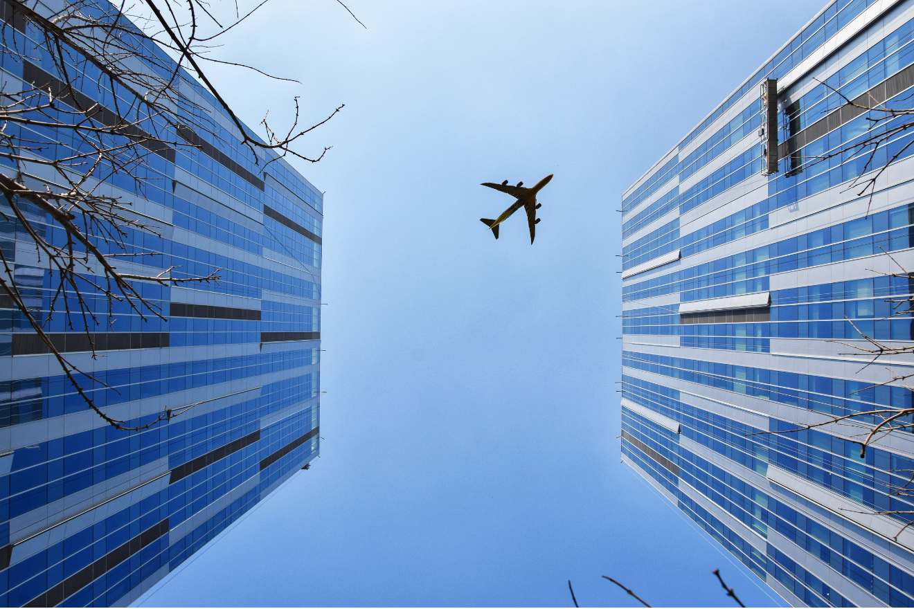 Airplane flying between buildings