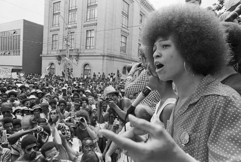 Angela Davis spricht vor einer Menschenmenge.