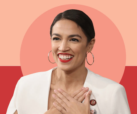 Rep Alexandria Ocasio-Cortez wearing red lips and large hoop earrings