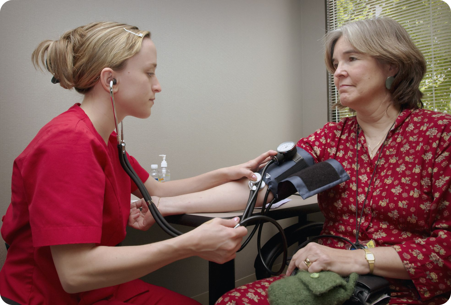 Nurse taking blood pressure of senior citizen