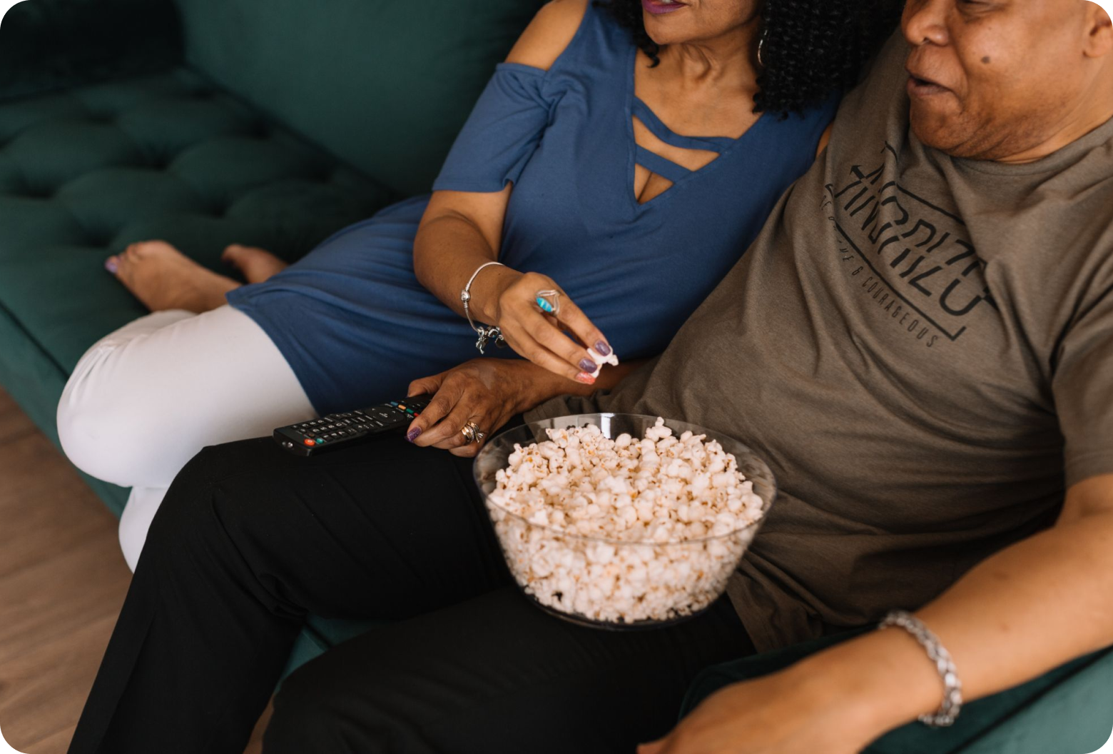 Couple on the couch watching a movie with popcorn