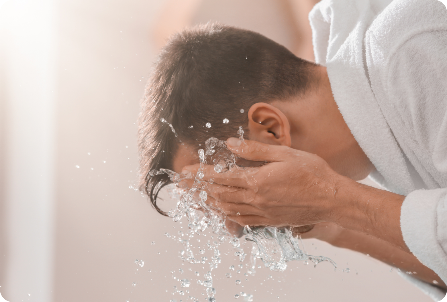 Image of man splashing his face with water