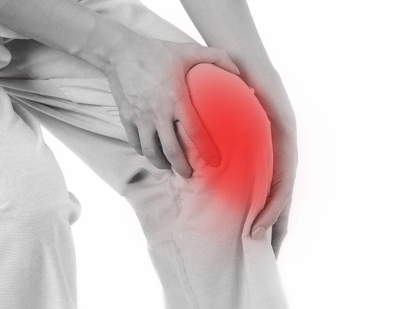 an image of a man holding his knee due to arthritis.