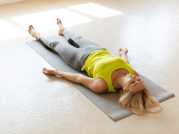 an image of a woman doing yoga, lying on her back.