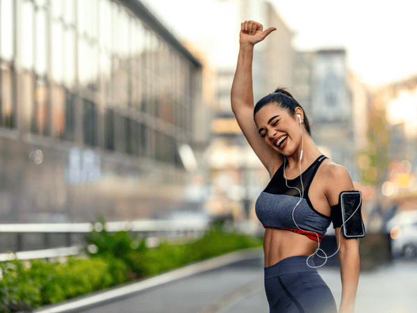 an image of a woman raising her hand in joy after working out.