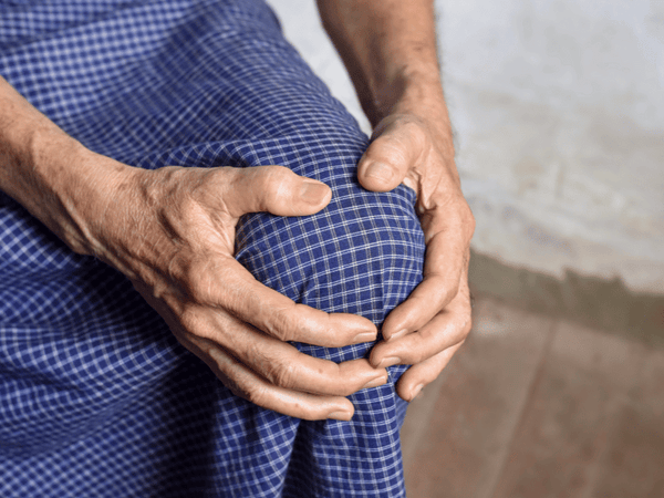 an image of a man holding his knee due to Bursitis