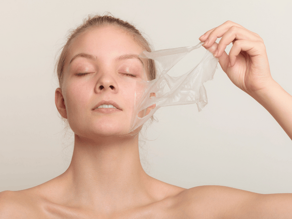 an image of a woman peeling of facial mask