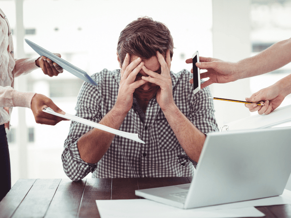 an image of a man in the office being bombarded with different tasks of his officemates.