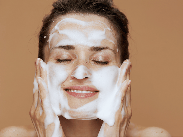 a woman washing her face.