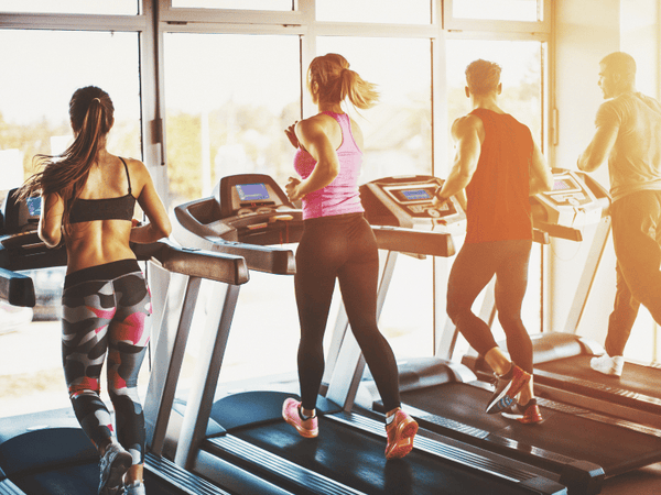 a group of people running on treadmills.