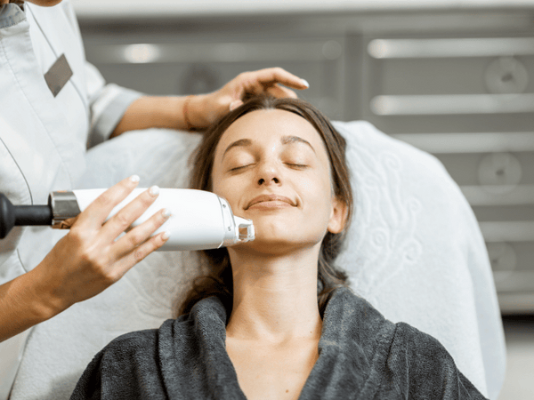 an image of a woman getting laser treatment on her face.