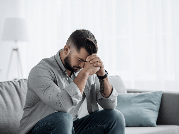 A man on prayer position who is dealing with anxiety and depression.