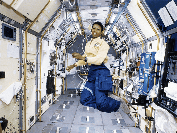 a woman wokring in NASA floating inside a space ship in outer space