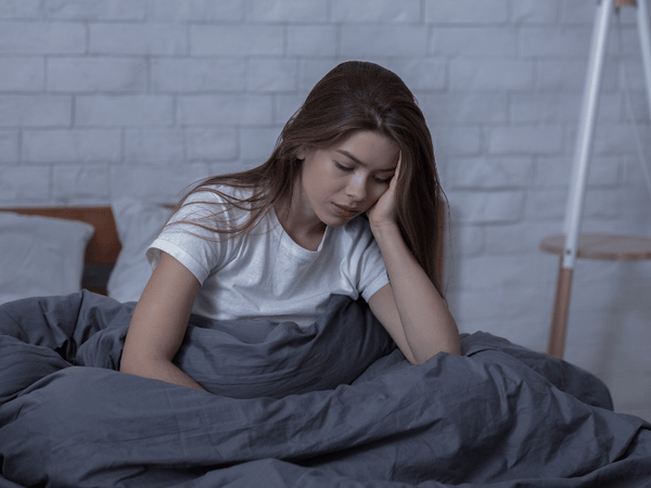 An image of a woman bed experiencing Seasonal Affective Disorder (SAD).