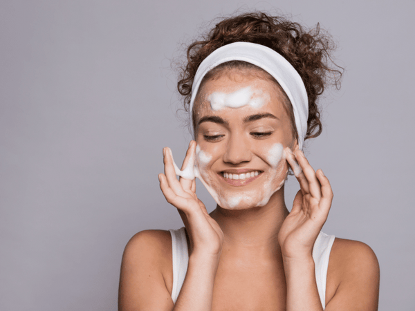 a woman using moisturizing soap on her face.