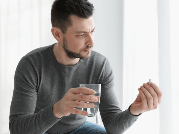 an image of a man abut to take medicine.