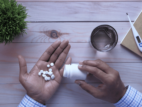 an image of a man spilling pills on his hand.