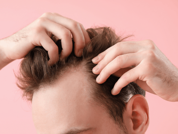 a man combing his hair with his hands.