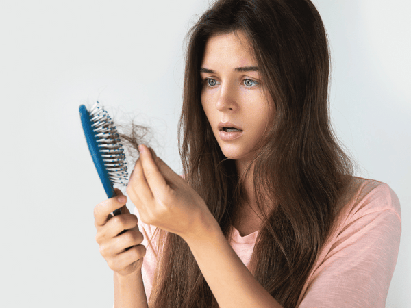 an image of a woman looking surprised as her hair falls off the comb