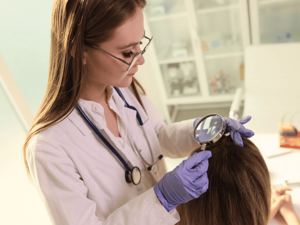 an image of a dermatologist checking on her patient's hair.