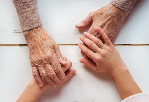 senior woman holding hands with loved one