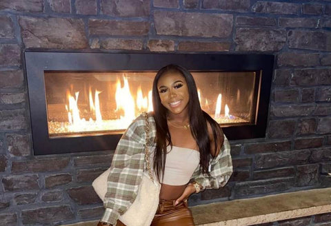 Brittni posing in front of a fireplace, looking pretty and cozy