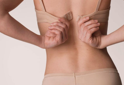 woman fastening a bra behind her back