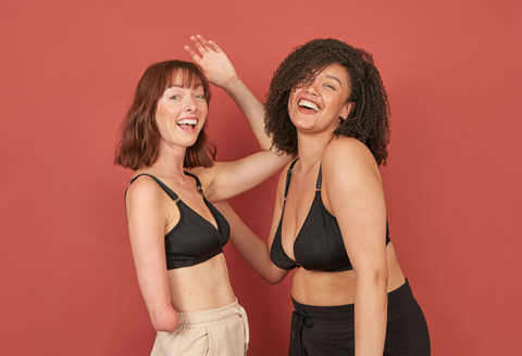 Two beautiful young, disabled women laughing at the camera while wearing the Springrose velcro front close bra
