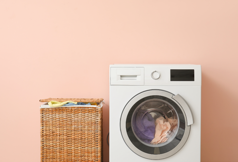 How to wash bras: a washing machine on a light pink background