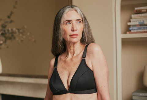 A beautiful older woman staring off into the distance while wearing Springrose's front closing bra for seniors