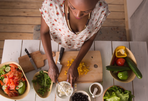 Overhead view of a woman preparing a salad in a home kitchen