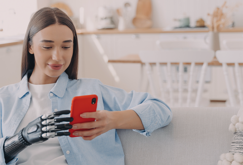 Adaptive Bra Velcro Closures: woman with prosthetic hand on a smartphone