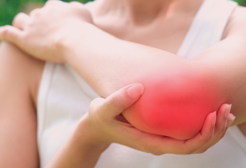 Recovery from tennis elbow surgery: a close up of a woman's elbow, with a red mark signifying inflamation