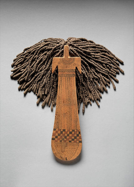 Paddle Doll: Made from a flat piece of wood, and formed into a very basic shape, that depicts a woman’s torso, neck, and arms, with strings of beads that are meant to imitate hair. 