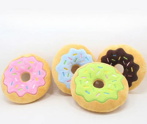 Strawberry, Blueberry, Lime and Chocolate Squeaky Donut Plush Toys placed on a blank background