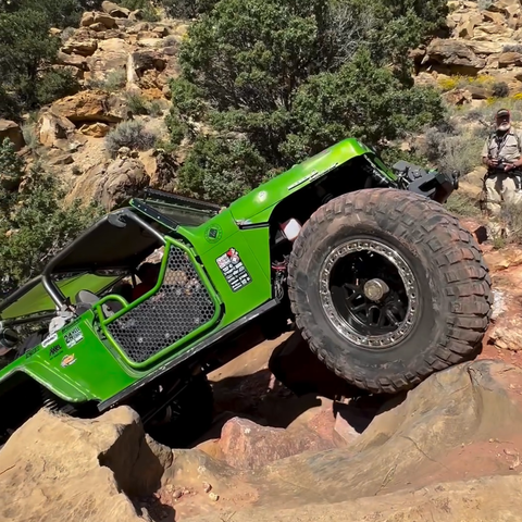 A jeep is skillfully scaling the rocks in a off-road challenge