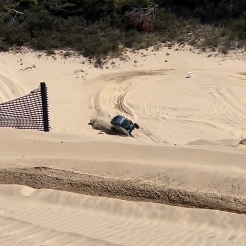 a dune buggy has reached an aggressive turn causing it to rollover.