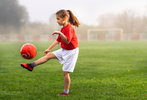 girl playing football in full training kit