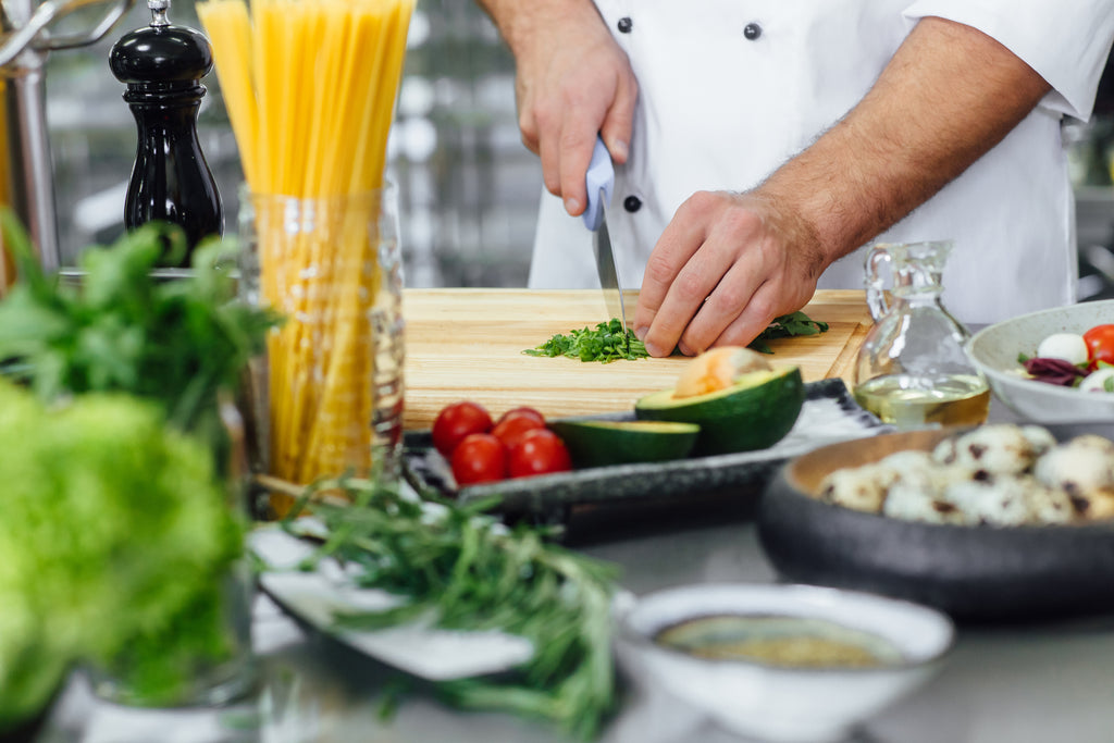 Chef chopping veg in a professional kitchen