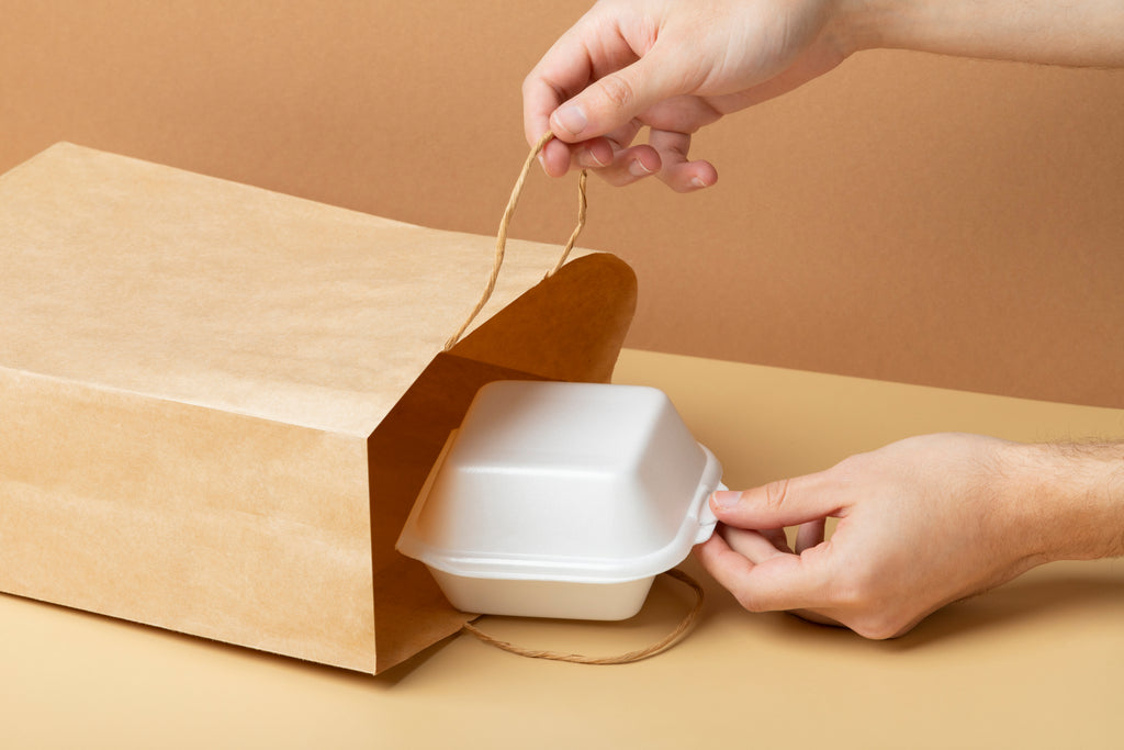 Takeaway packaging being removed from brown paper takeaway bag